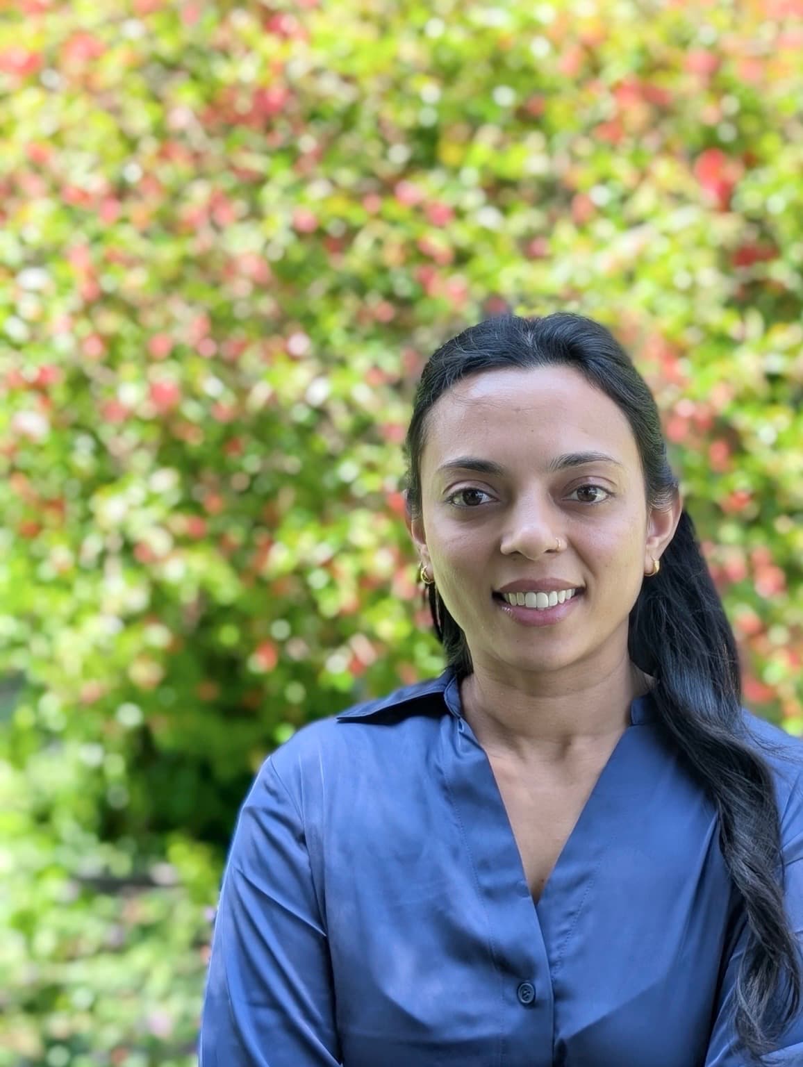 Payal, founder of Integrity Senior Care, smiling outdoors in a navy shirt.
